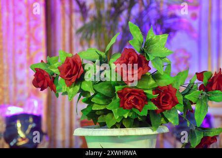 Künstliche Rosen in Töpfen, dekorative rote Rosen auf der Kunststoffvase. Stockfoto