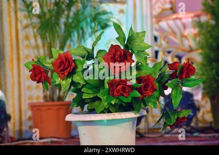 Künstliche Rosen in Töpfen, dekorative rote Rosen auf der Kunststoffvase. Stockfoto