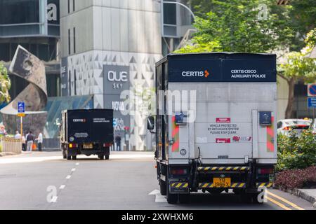 Rückansicht von zwei gepanzerten Sicherheitsfahrzeugen, die auf der Straße unterwegs sind und für Wertsachen wie Geld verantwortlich sind. Singapur. Stockfoto