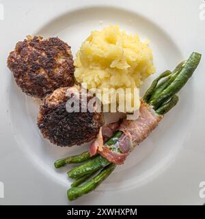 Hamburg, Deutschland. August 2024. Fleischbällchen mit grünen Bohnen und Kartoffelpüree liegen auf einem Teller. Quelle: Markus Scholz/dpa/Alamy Live News Stockfoto