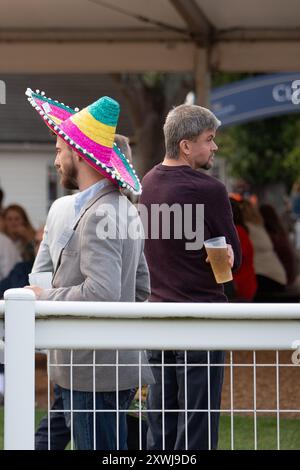 Windsor, Berkshire, Großbritannien. August 2024. Es war ein luftiger Abend mit zeitweiligem Sonnenschein, als die Rennfahrer das mexikanische Pferderennfinale auf der Royal Windsor Racecourse in Windsor, Berkshire, genossen. Einige Racegoer haben sich mit Sombreros in das mexikanische Thema eingelassen. Quelle: Maureen McLean/Alamy Live News Stockfoto