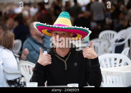 Windsor, Berkshire, Großbritannien. August 2024. Es war ein luftiger Abend mit zeitweiligem Sonnenschein, als die Rennfahrer das mexikanische Pferderennfinale auf der Royal Windsor Racecourse in Windsor, Berkshire, genossen. Einige Racegoer haben sich mit Sombreros in das mexikanische Thema eingelassen. Quelle: Maureen McLean/Alamy Live News Stockfoto