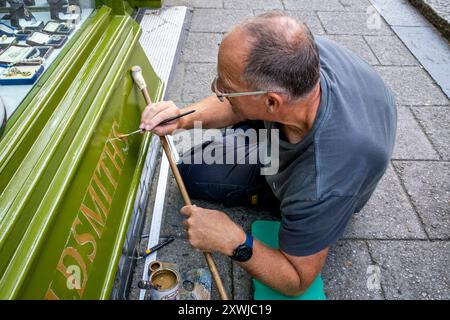 Ein Signwriter bei der Arbeit in der High Street, Lewes, East Sussex, Großbritannien. Stockfoto