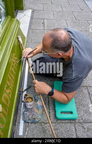 Ein Signwriter bei der Arbeit in der High Street, Lewes, East Sussex, Großbritannien. Stockfoto