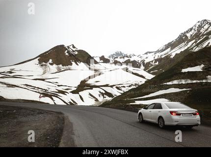 Einsame weiße Limousine auf der Bergstraße Stockfoto