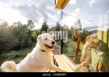 Freudige Interaktion zwischen Frau und Hund durch Glas Stockfoto