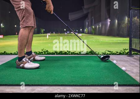 Ein Mann, der mit Golfschaukel auf dem Golfplatz auf der Driving Range spielt und trainiert Stockfoto