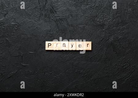 GEBETSWORT auf Holzblock geschrieben. GEBETSTEXT auf Zementtisch für Ihr Design, Konzept. Stockfoto