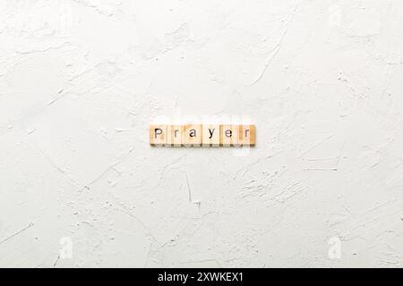GEBETSWORT auf Holzblock geschrieben. GEBETSTEXT auf Zementtisch für Ihr Design, Konzept. Stockfoto