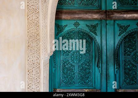 Verzierte türkisgrüne blaue marokkanische Bogentür Hintergrund, ornamental geschnitztes Holz, innen, der Turm am Le Jardin Secret, Marrakesch, Marokko Stockfoto