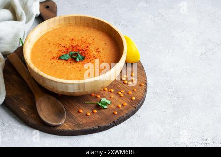 Traditionelle türkische rote Linsensuppe mit Zutaten in einer Schüssel auf rustikalem Tisch Stockfoto