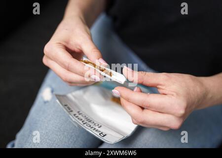 Eine Frau dreht sich eine Zigarette in Berlin, 08.08.2024. Berlin Deutschland *** Eine Frau, die in Berlin eine Zigarette rollt, 08 08 2024 Berlin Deutschland Polizist Stockfoto