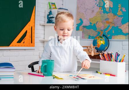Süßer Schüler mit lustiger Gesichtsschularbeit. Heimschule für Schüler. Die Kinder machen sich bereit für die Schule. Grundschulklasse. Stockfoto