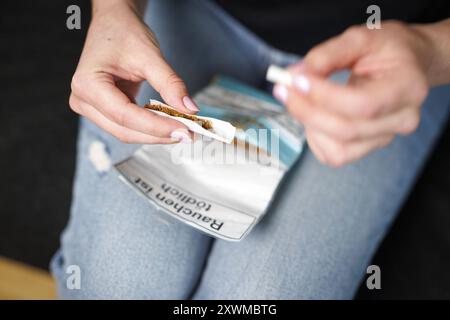 Eine Frau dreht sich eine Zigarette in Berlin, 08.08.2024. Berlin Deutschland *** Eine Frau, die in Berlin eine Zigarette rollt, 08 08 2024 Berlin Deutschland Polizist Stockfoto