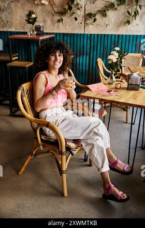 Eine Frau in stilvoller Kleidung genießt ein Getränk in einem Café in Europa. Stockfoto