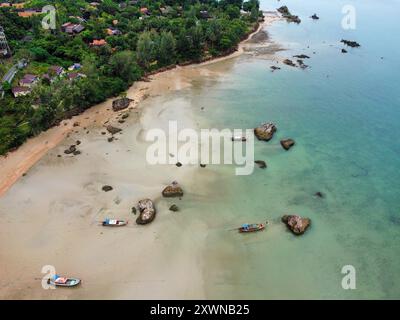 Blick aus der Vogelperspektive auf einen tropischen Strand in Thailand mit Langboot-Booten Stockfoto