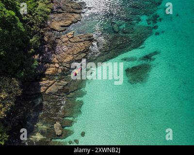 Blick aus der Vogelperspektive auf den tropischen Strand auf der Insel Koh Kood in Thailand mit türkisfarbenem Wasser, Felsen, dichter Vegetation und einem Kajak Stockfoto