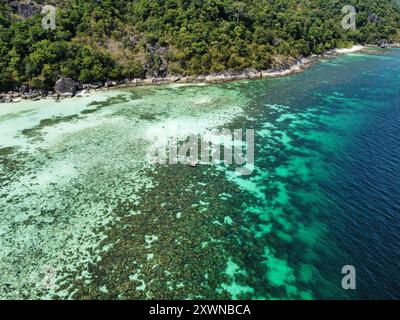 Aus der Vogelperspektive auf das Korallenriff von Koh Ra Wi mit der Insel im Hintergrund bei Ebbe Stockfoto