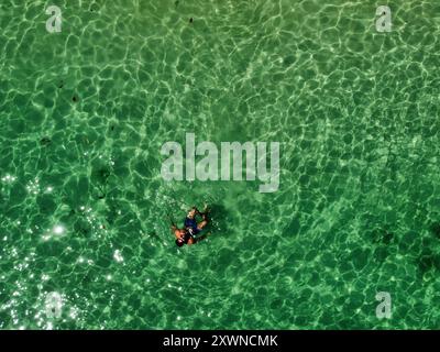Aus der Vogelperspektive auf europäische Reisende, die im tropischen Wasser von Koh Ngai schwimmen und entspannen Stockfoto