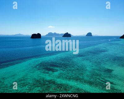 Blick aus der Vogelperspektive auf den Strand Ko Ngai mit seinem fantastischen Korallenriff und türkisfarbenem Wasser und anderen Trang-Inseln im Hintergrund Stockfoto