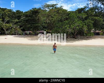 Junger Ausländer, der am tropischen Strand von Koh Kradan spaziert Stockfoto