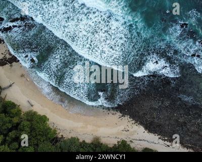 Wellen brechen mit den Felsen am Sunset Beach von Koh Kradan zusammen Stockfoto