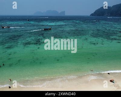 Blick aus der Vogelperspektive auf den Long Beach auf Koh Phi Phi Don, mit langen Segelbooten und Koh Phi Phi Le im Hintergrund an einem nebeligen Tag Stockfoto