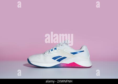 Straßburg, Frankreich - August 2024: Neue Trainingsschuhe Reebok Nano X4 auf rosa und weißem Hintergrund von der Seite. Stylische Schwarzweiß-Schuhe für aktive Stockfoto