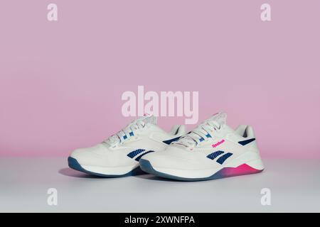 Straßburg, Frankreich - August 2024 : neue Trainingsschuhe Reebok Nano X4 auf rosa-weißem Hintergrund, Seitenansicht. Stylische, farbenfrohe Schuhe für aktive Menschen Stockfoto