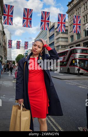 London - 06 11 2022: Girl frisiert sich nach dem Einkaufen in der Oxford St die Haare Stockfoto