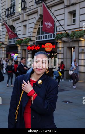 London - 06 11 2022: Mädchen hält ihr Lächeln im Piccadilly Circus zurück Stockfoto