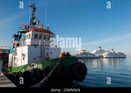 Lokales Schleppboot, die Altair, IMO 8030831, im Hafen von Split, Kroatien. Großes Schiff/Fähren im Hintergrund. Schöner Sommertag, Sonne und blauer Himmel. (138) Stockfoto