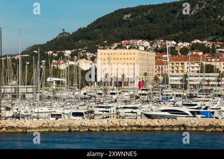 ACI Marina; Anlegeplatz für Yachten in Split, Kroatien, und Hafenküste von einem Boot, das im Hafen segelt. Schöner Sommermorgen mit blauem Himmel. (138) Stockfoto