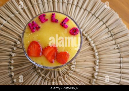 Blick von oben auf ein tropisches Fruchtsaftgetränk mit Obst, das das Wort Hallo ausdrückt Stockfoto