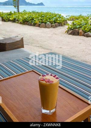 Tropisches Fruchtsaftgetränk mit Früchten, die das Wort Hallo auf einem Tisch am tropischen Strand in Indonesien ausdrücken Stockfoto