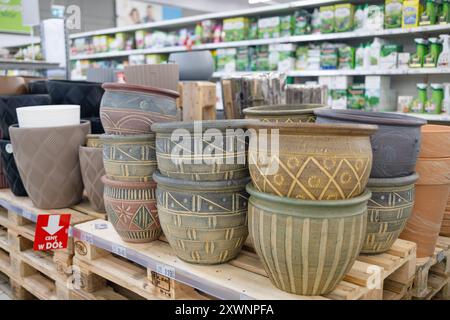 Viele bunte Blumentöpfe in verschiedenen Größen in einem Gartengeschäft. Reihen dekorativer Keramiktöpfe für Zimmerpflanzen. Keramik- und Tonkeramik Stockfoto