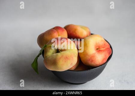 Nahaufnahme einer Schüssel mit Reifen Pfirsichen auf einem Tisch Stockfoto
