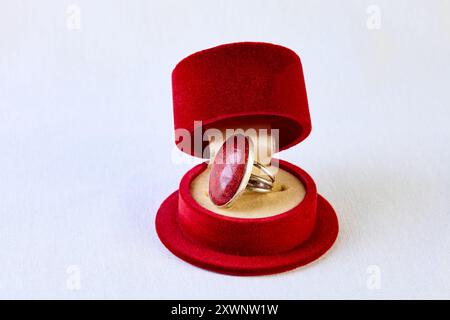 Antikes offenes Ringkästchen in Form eines Männerhutes. Aus rotem Samt. Ring mit rotem Stein Stockfoto