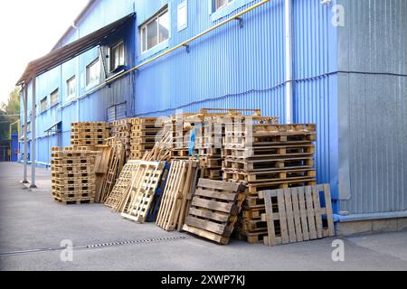 Holzpaletten im Außenbereich des Industriegebäudes Logistik, Lagerhaltung, Versandmaterial und Lieferkettenkonzept Stockfoto
