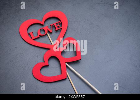 Herzförmige Zeichen mit dem Wort „Liebe“, um Ihren Lieben auf dunklem Hintergrund Ihre Gefühle auszudrücken Stockfoto