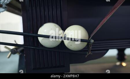 Zwei weiße Billardkugeln im Kugelrücklauf. Billardtisch-Mechanismus, Spielausrüstung, Sportanlage Detailaufnahme. Stockfoto