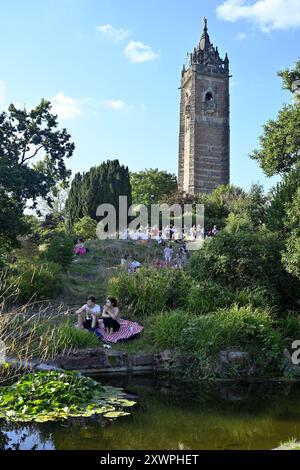 Warmer, sonniger Tag mit Familie und Freunden auf dem Gras unter dem Cabot Tower auf Brandon Hill, Bristol, Großbritannien. Der Cabot Tower wurde 1897 gebaut Stockfoto