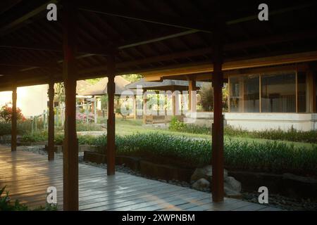 Pavillon mit einem Holzsteg, umgeben von traditioneller japanischer Architektur, einem Pavillon und einem tropischen Garten Stockfoto