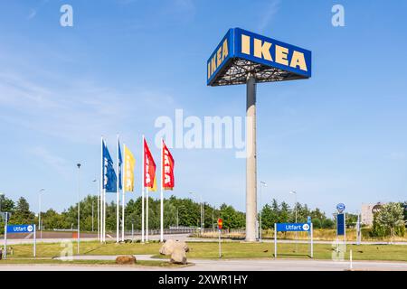 Eine hohe dreiseitige Reklametafel zeigt das IKEA-Schild am Eingang des IKEA-Geschäfts in Malmö, Schweden, neben IKEA-Bannern. Stockfoto