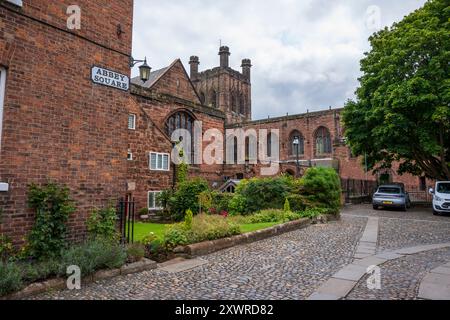 Historische Backsteingebäude und kopfsteingepflasterte Straßen am Abbey Square mit einer mittelalterlichen Kathedrale im Hintergrund. Chester Großbritannien. Stockfoto