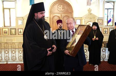 Baku, Aserbaidschan. August 2024. Der russische Präsident Wladimir Putin, rechts, stellt dem Bischof von Baku und Aserbaidschan Aleksiy Smirnow, links, während eines Besuchs in der Heiligen Myrrrhträgerkirche am 19. August 2024 in Baku, Aserbaidschan, eine Ikone der Verklärung des Herrn vor. Quelle: Vyacheslav Prokofyev/Kreml Pool/Alamy Live News Stockfoto