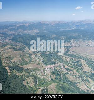 Panoramablick aus der Luft, von einem Segelflugzeug aus, mit dem Dorf Cesaproba, aufgenommen von Westen im hellen Sommerlicht, Apennin, L'Aquila, Abruzzen, Italien Stockfoto