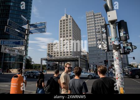 Berlin, Deutschland. August 2024. Am 20. August 2024 wartet eine Gruppe auf die Überquerung der Straße am Potsdamer Platz mit Hochhäusern und Verkehr im Hintergrund. Der Platz, ein Beweis für die rasche Modernisierung Berlins, ist heute ein stiller Zeuge der Konjunkturprognosen der Bundesbank. (Foto: Michael Kuenne/PRESSCOV/SIPA USA) Credit: SIPA USA/Alamy Live News Stockfoto