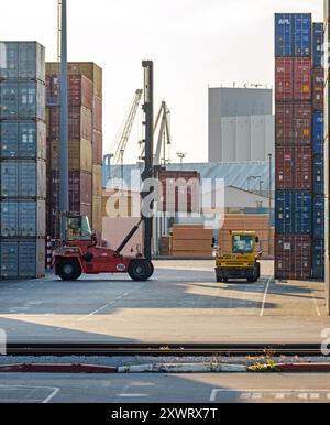 Koper, Slowenien - 17. Juni 2019: Heavy Duty Container Handler Machine Lifting Container and Lading Truck in Port Yard. Stockfoto