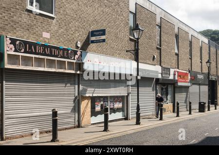 Ein Mann läuft an befahrenen Geschäften im Stadtzentrum von Houghton le Spring, Tyne and Wear, England, vorbei Stockfoto
